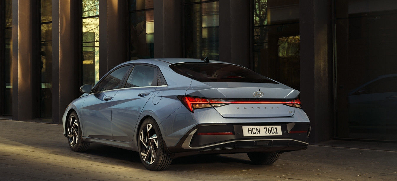 Side-front view of orange Grandi10 with lakeside view at night