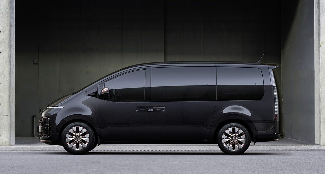 Side-front view of orange Grandi10 with lakeside view at night